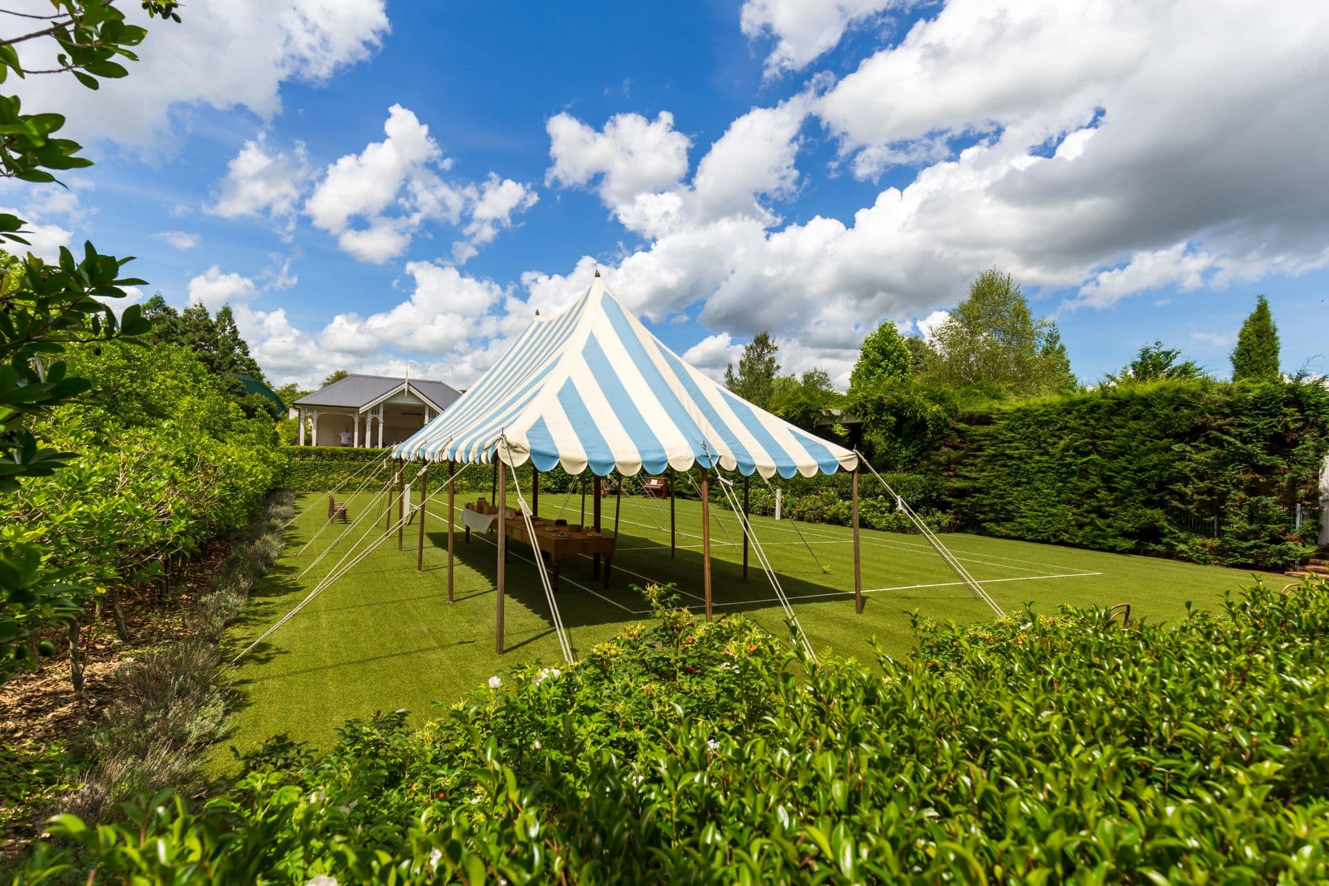 Blau-weißer Gartenpavillon auf gepflegtem Rasen, ideal für Fitness, Entspannung und geschützte Outdoor-Aktivitäten.