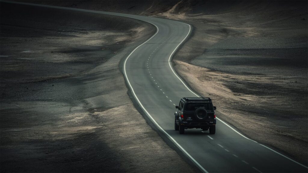 Geländewagen mit Zusatzscheinwerfern auf leerer Wüstenstraße